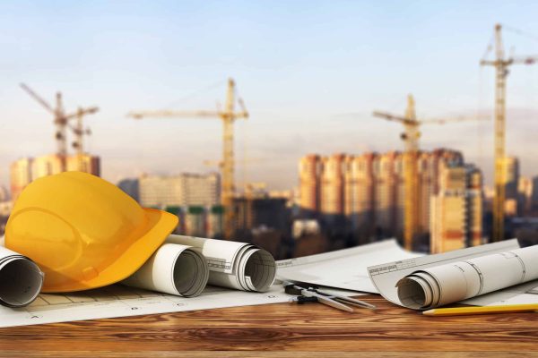 Concept of construction and design. 3d render of blueprints and designer tools on the panorama of construction site.